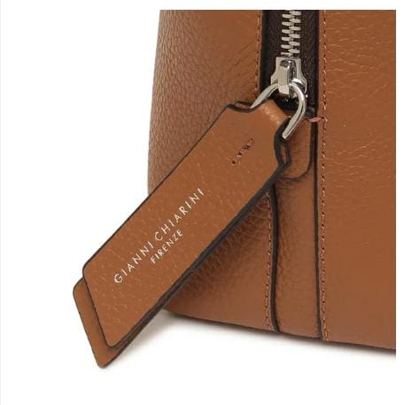 Primo piano della borsa in pelle marrone di GIANNI CHIARINI. Ha una cerniera in metallo e una targhetta in pelle con la scritta "GIANNI CHIARINI FIRENZE" in bianco. È prodotto in Italia e trasuda un'eleganza italiana senza tempo.